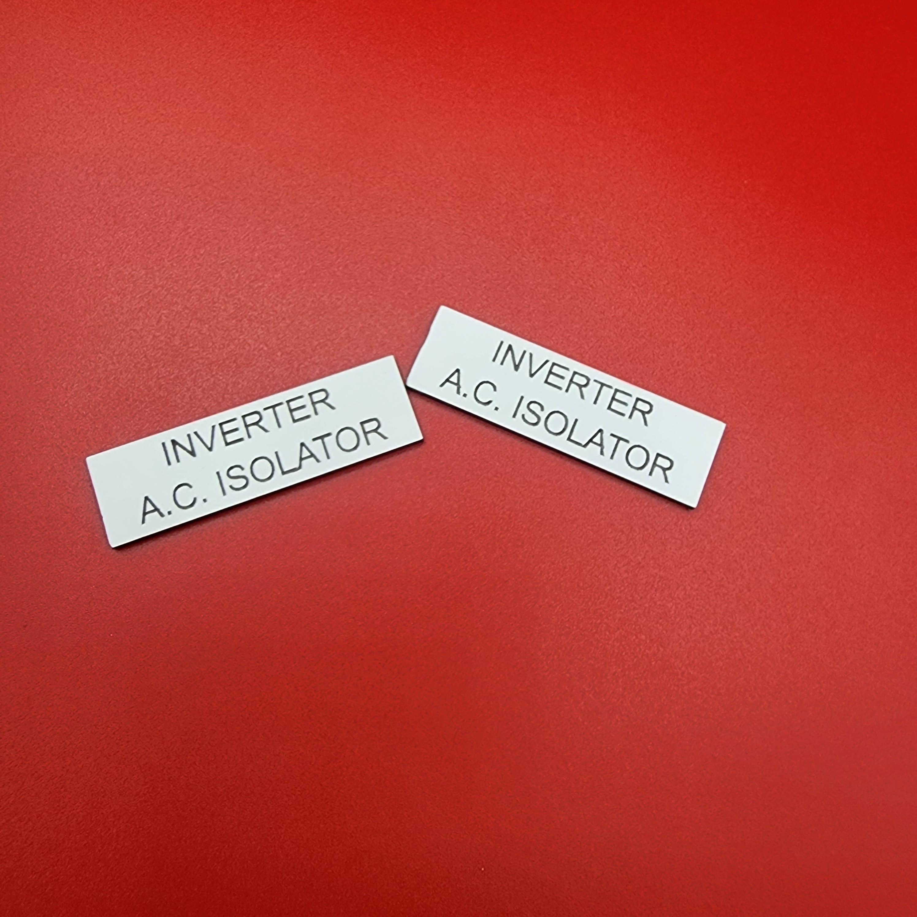 Two inverter AC isolator labels showing consistent engraving quality