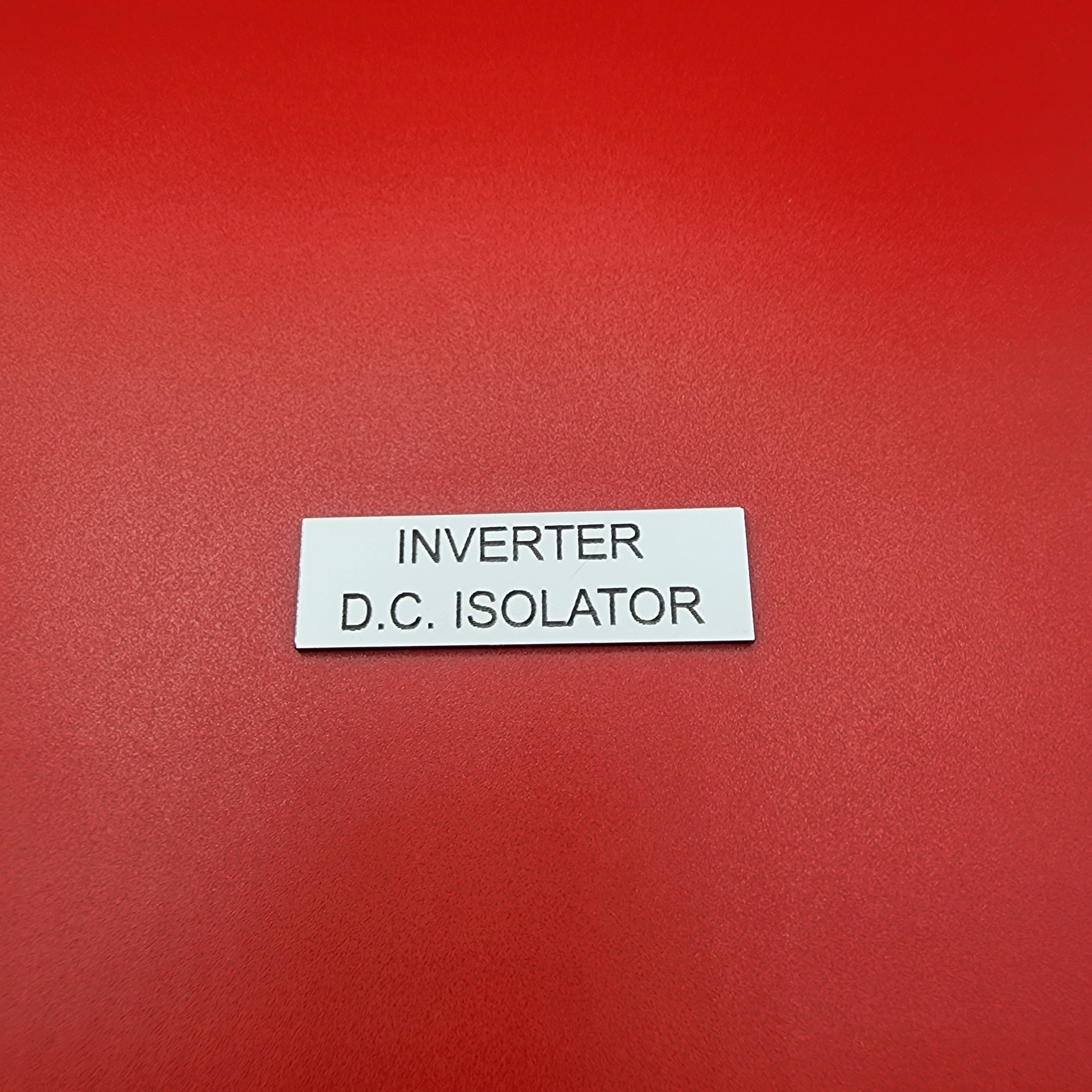 White traffolyte DC isolator label with black engraved text