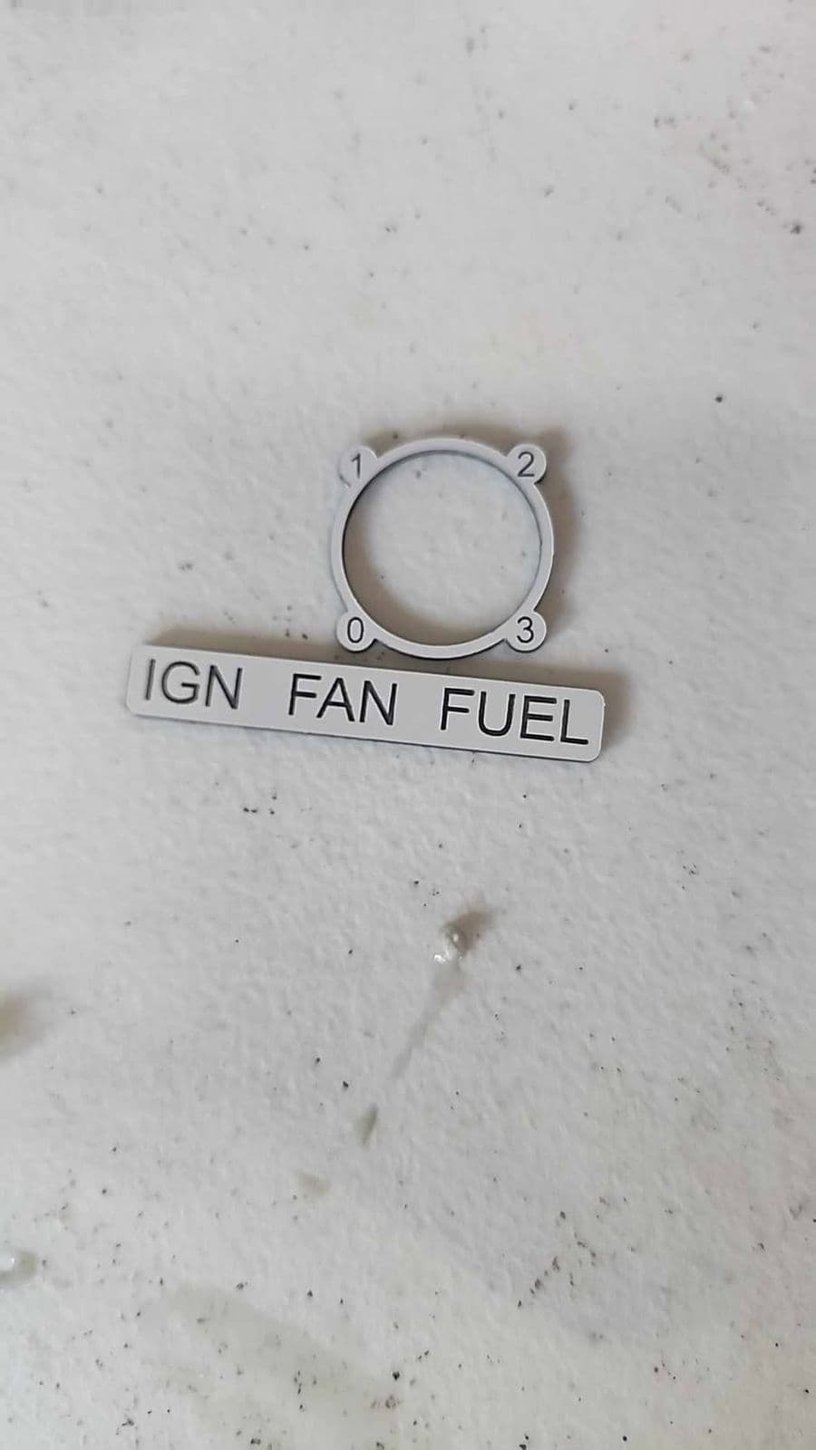 Close-up of a grey traffolyte selector surround plate numbered 0-1-2-3 next to an IGN FAN FUEL switch label