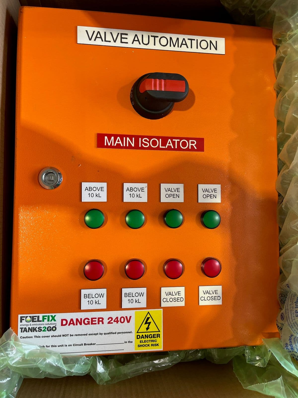 Orange valve automation control panel with white engraved legend labels, a red Main Isolator label, and green and red indicator lamps