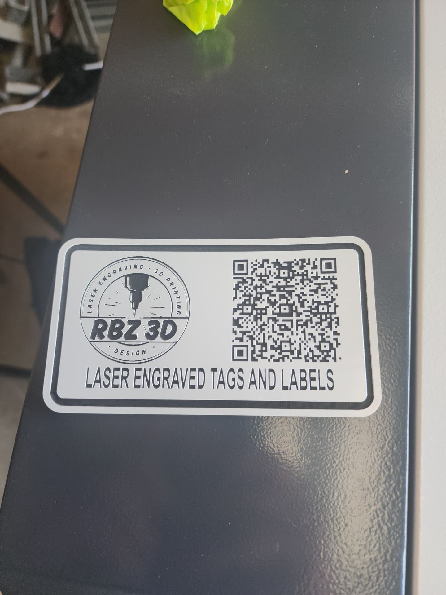 Laser engraved two-ply QR code tag fixed to grey equipment housing